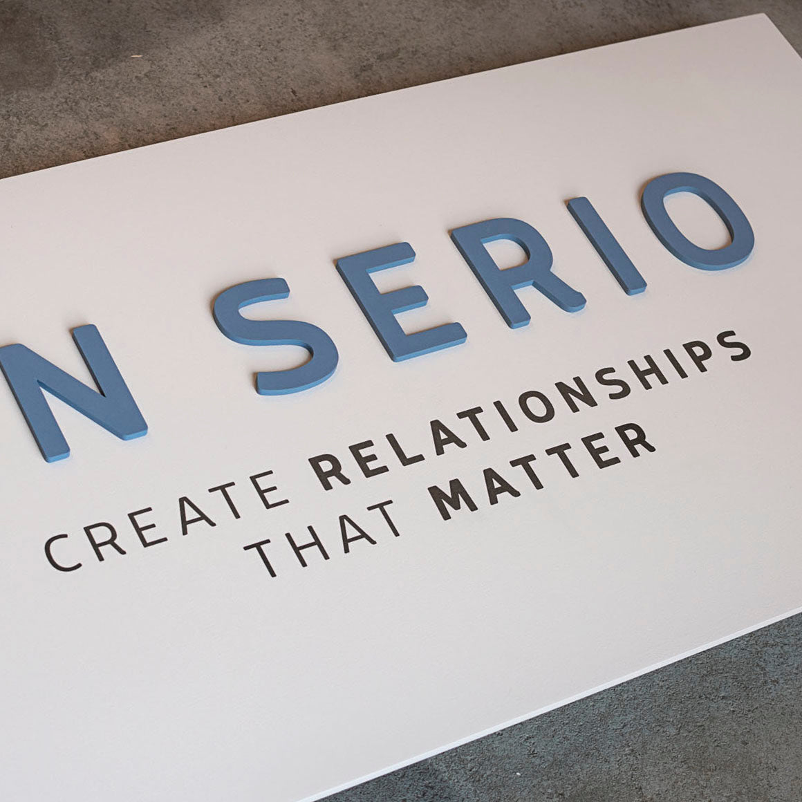 Logo de lettre sur une planche en bois blanche